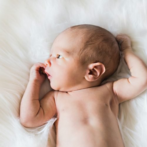 White baby lying down and looking to the side – by Irina Murza – Birth, Baby & You – Dee Bell – Lactation Consultant for Kent, Surrey & Sussex